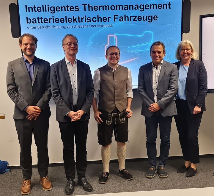 Johannes Stockhammer in lederhosen with four others in front of the dissertation's title slide after the defense